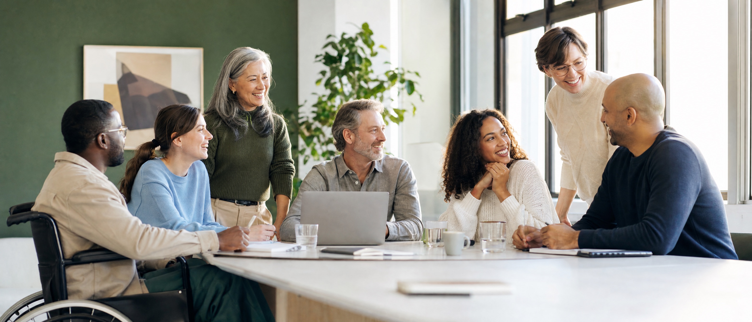 Diverse group of professionals in respectful, engaged conversation around a table